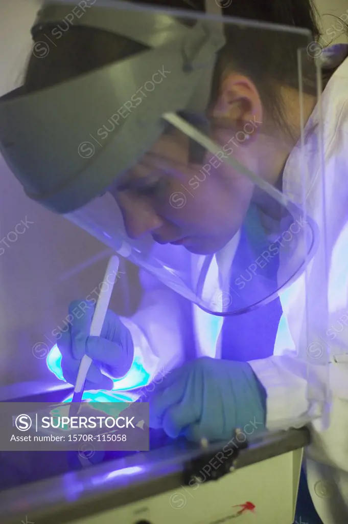 Scientist using scalpel and ultraviolet light for DNA isolation