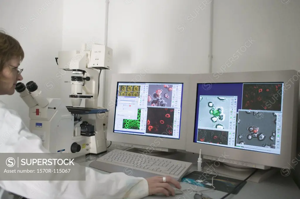 Technician using computer aided microscope in a laboratory