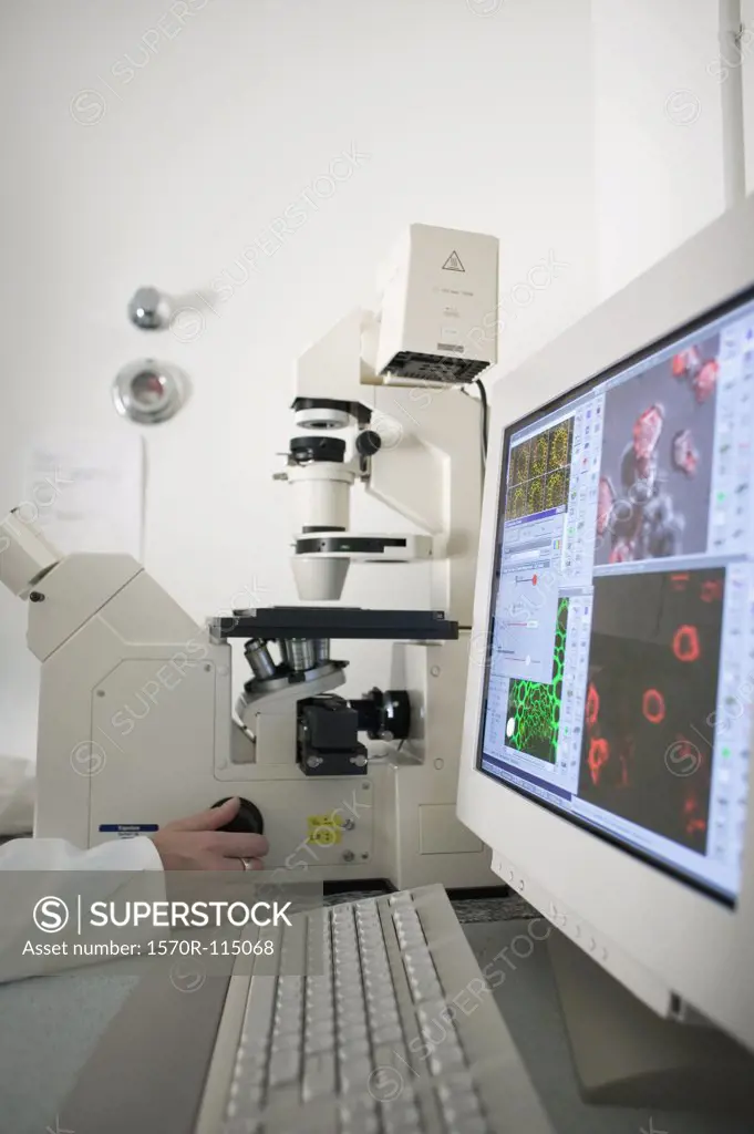 Technician using computer aided microscope in a laboratory