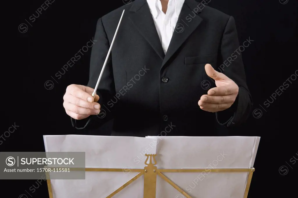 Conductor standing behind stand with sheet music