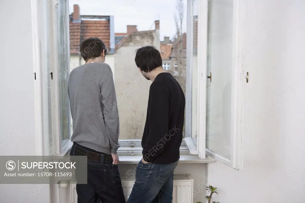 Two young men looking out of window