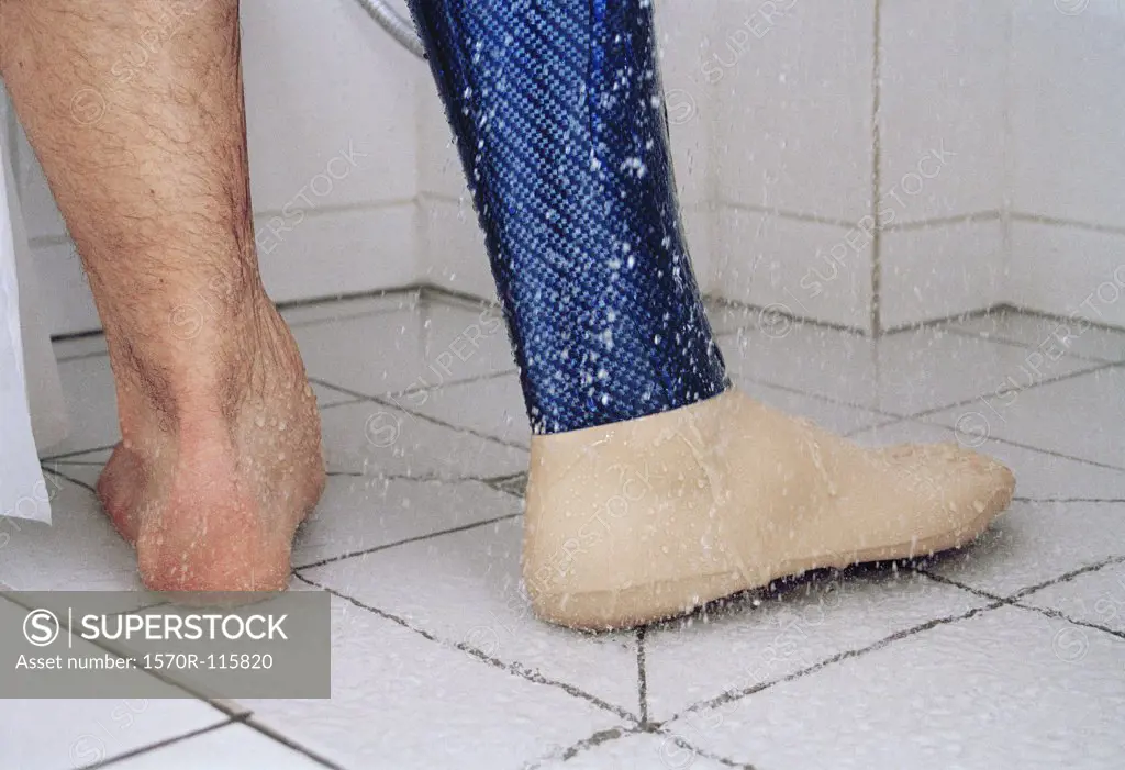 Low section of man showering with prosthetic leg