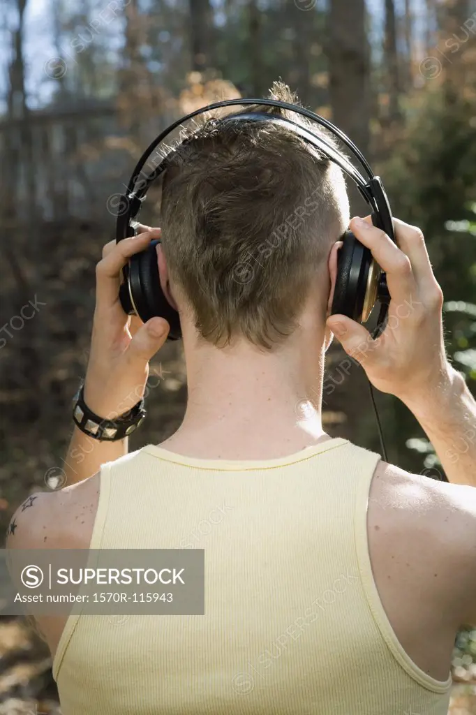 Man standing in the woods and wearing headphones