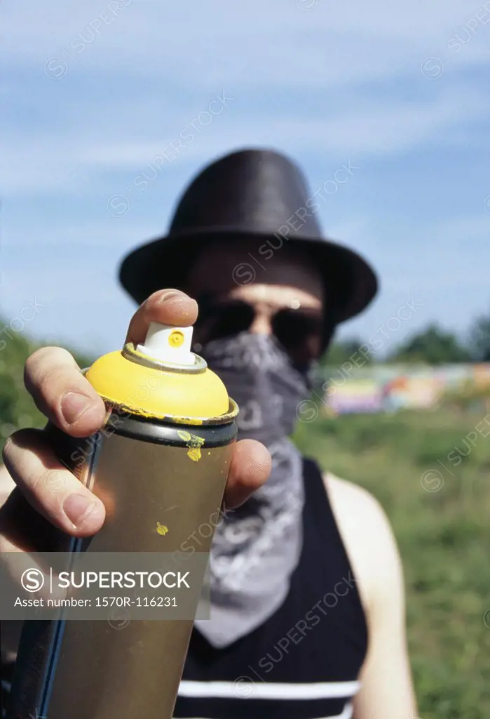 A man holding a can of spray paint