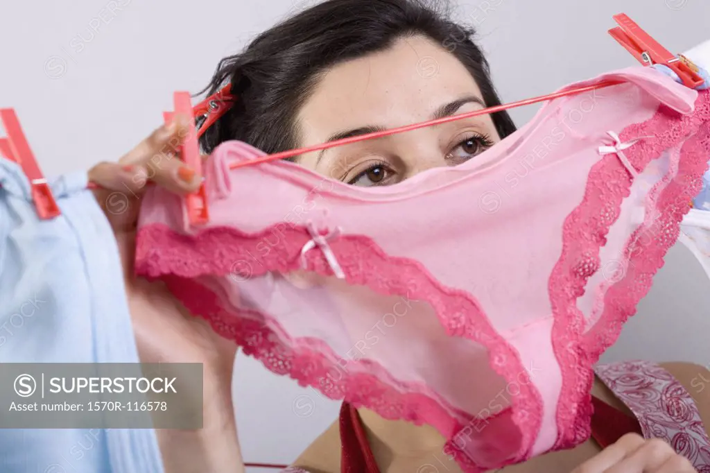 A woman hanging underwear on a clothesline - SuperStock