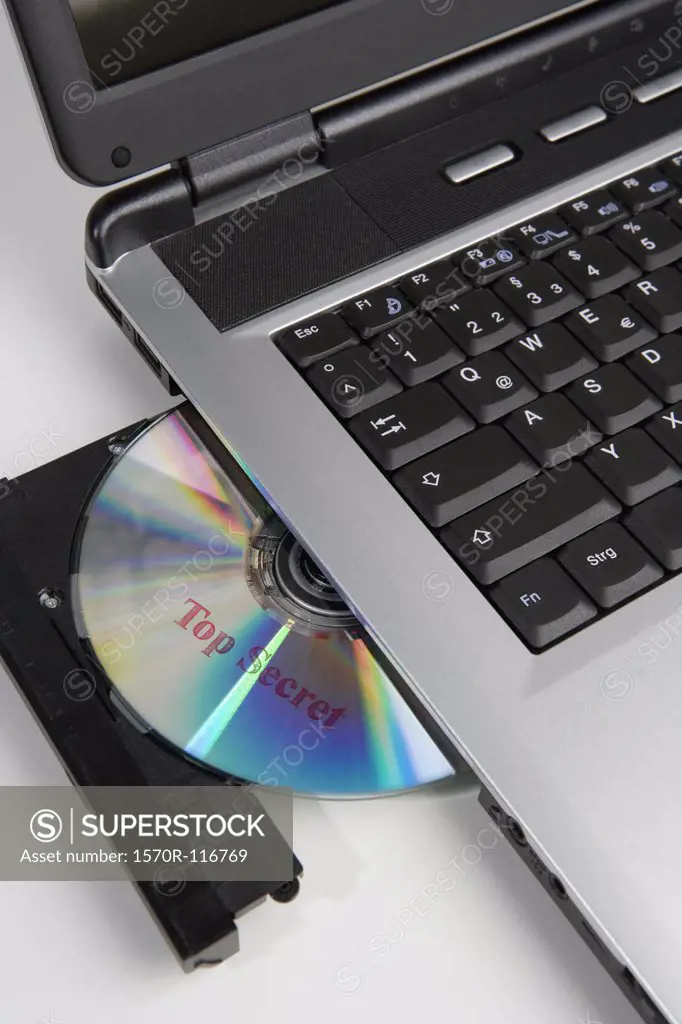 A CD stamped 'Top Secret' in the disc drive of a laptop computer