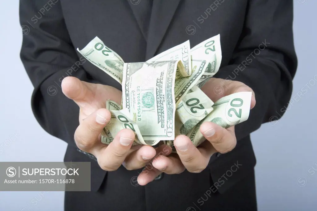 A businessman with a handful of US bank notes