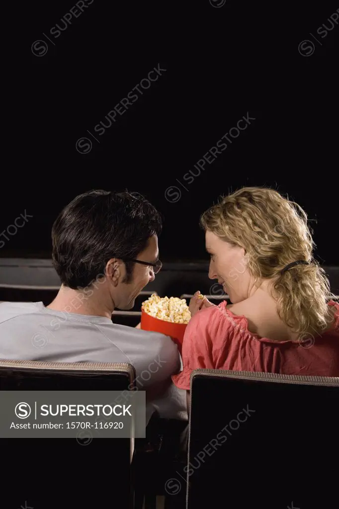 Rear view of a mid adult couple sitting in a movie theater