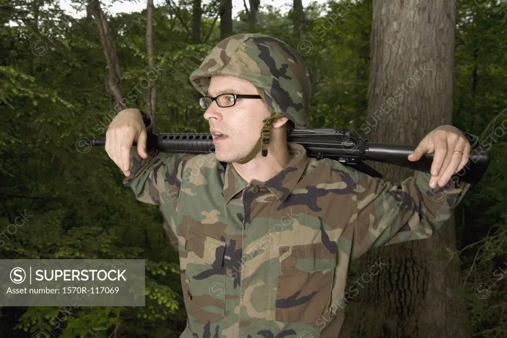 Soldier resting a gun across his shoulders