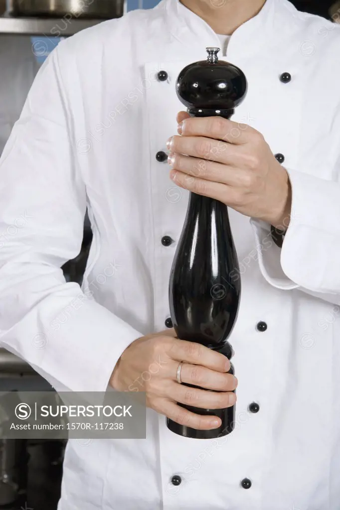 A chef holding a pepper mill