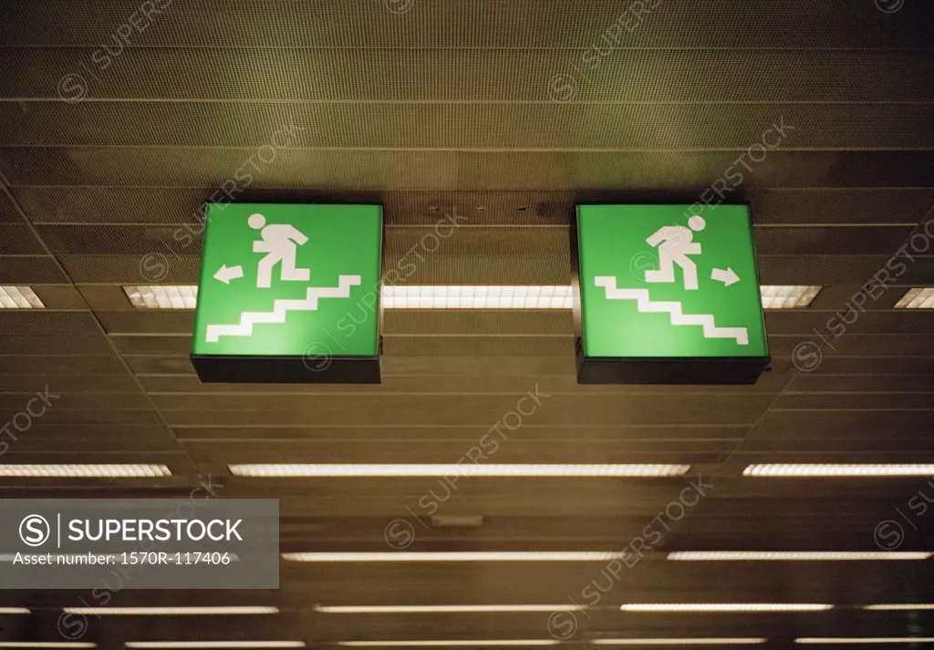 Illuminated emergency exit signs on a ceiling