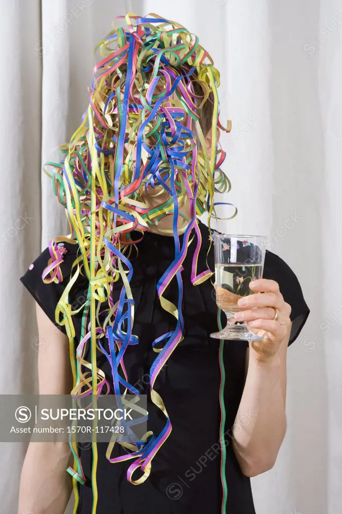 A woman covered in streamers and holding a glass of champagne