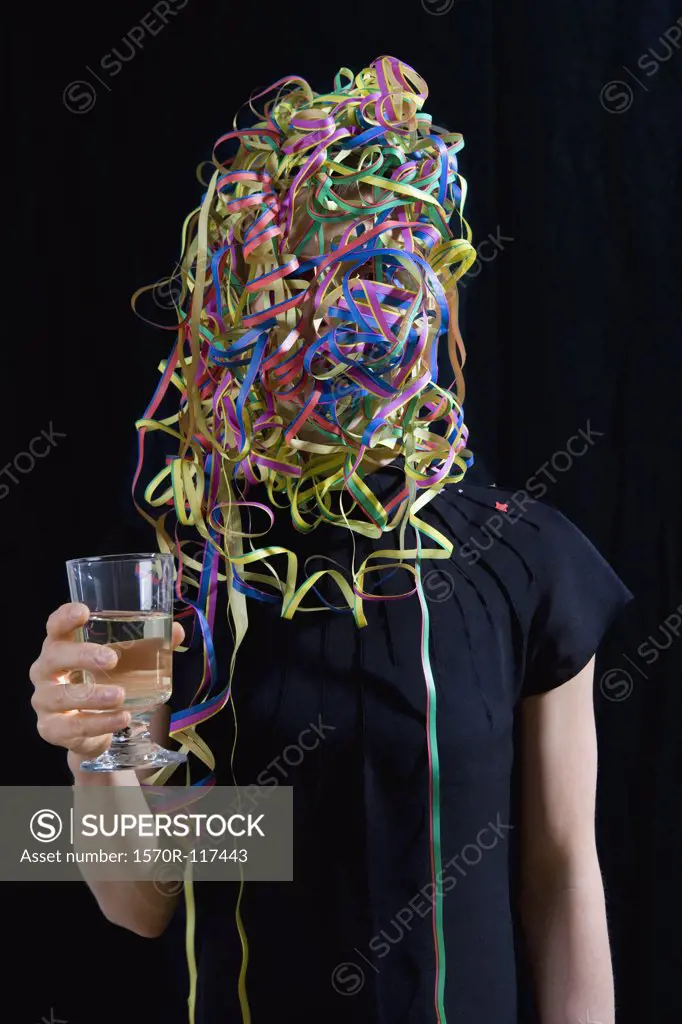 A woman covered in streamers and holding a glass of champagne