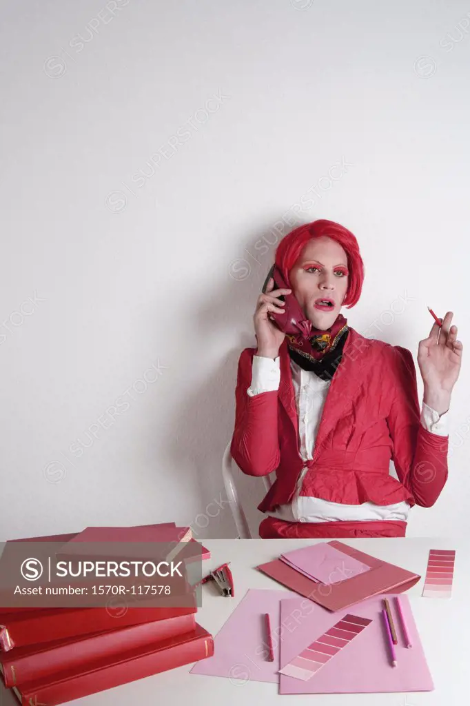 Drag queen sitting at a desk