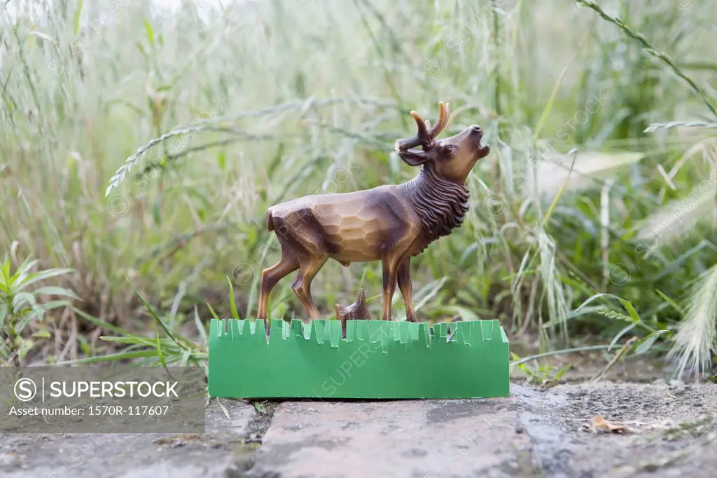 A plastic deer figurine on a garden path