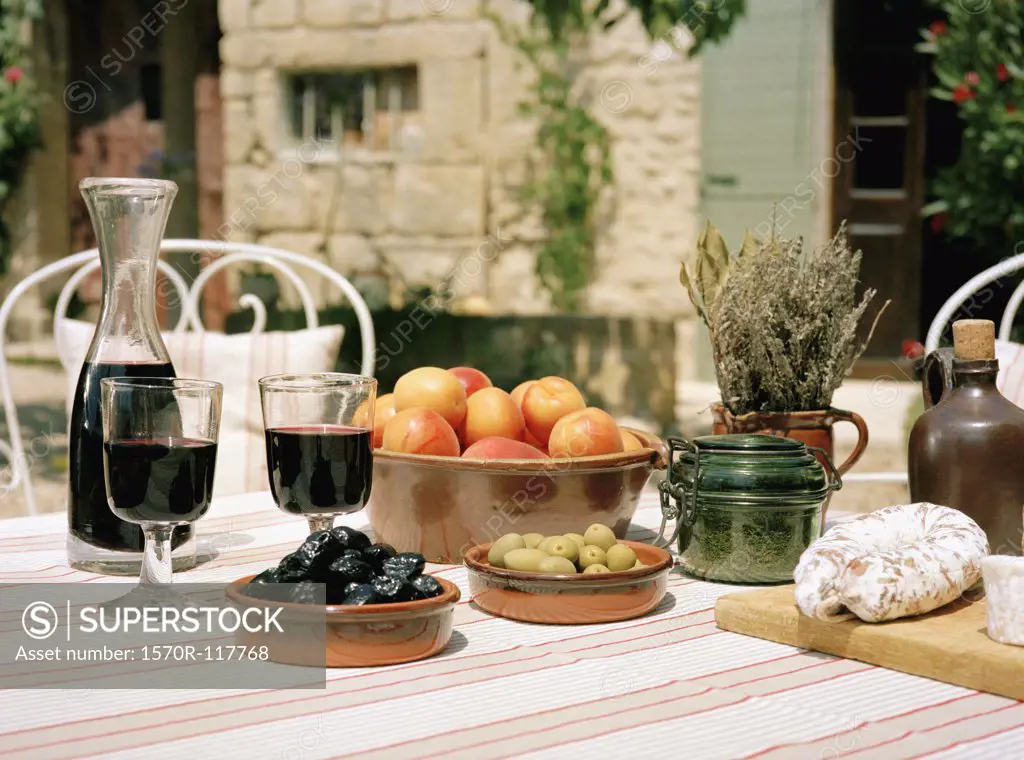 An outdoor table set with wine and appetizers