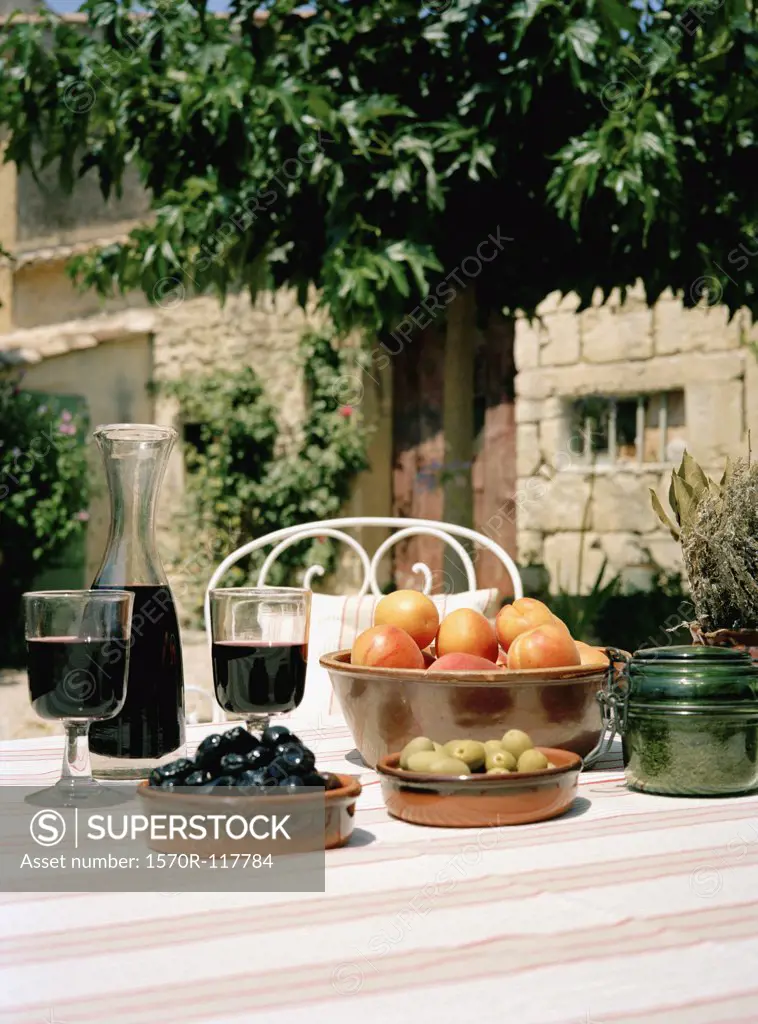 An outdoor table set with wine and appetizers