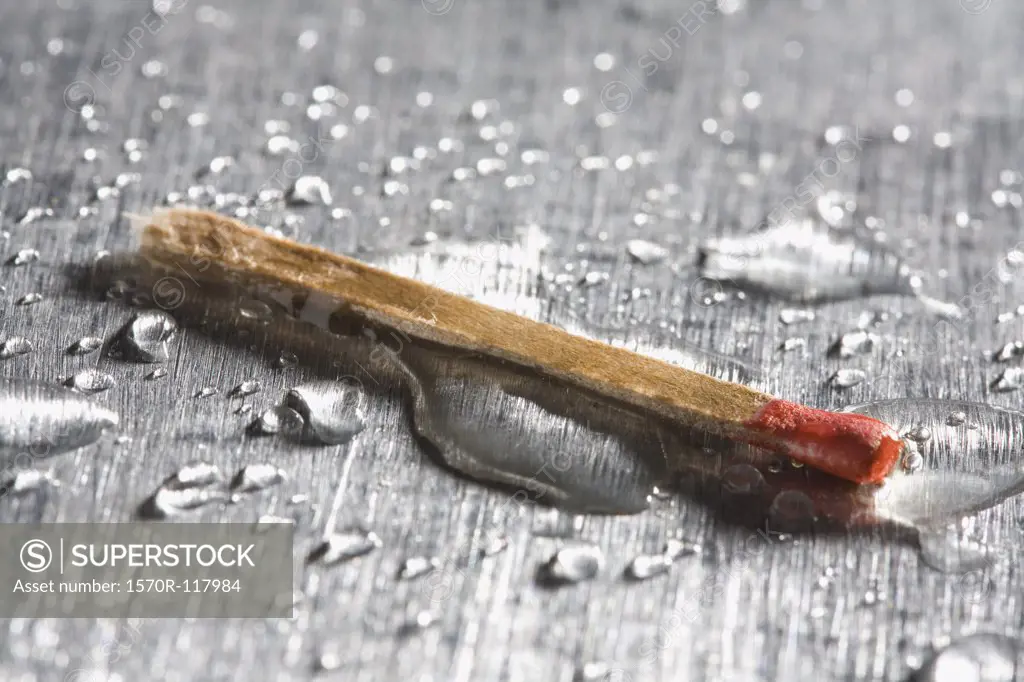 A matchstick with drops of water