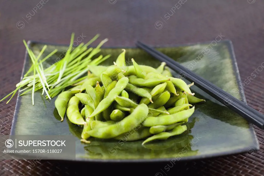 Edamame on a plate with chopsticks