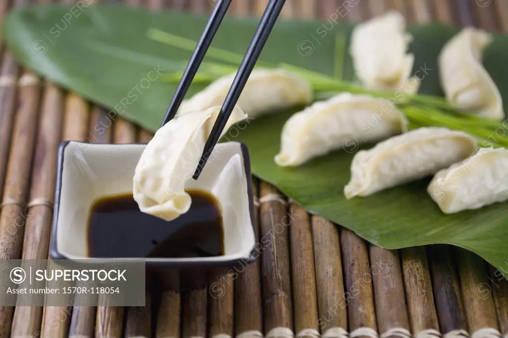 Chopsticks with Gyoza dumplings and soy sauce