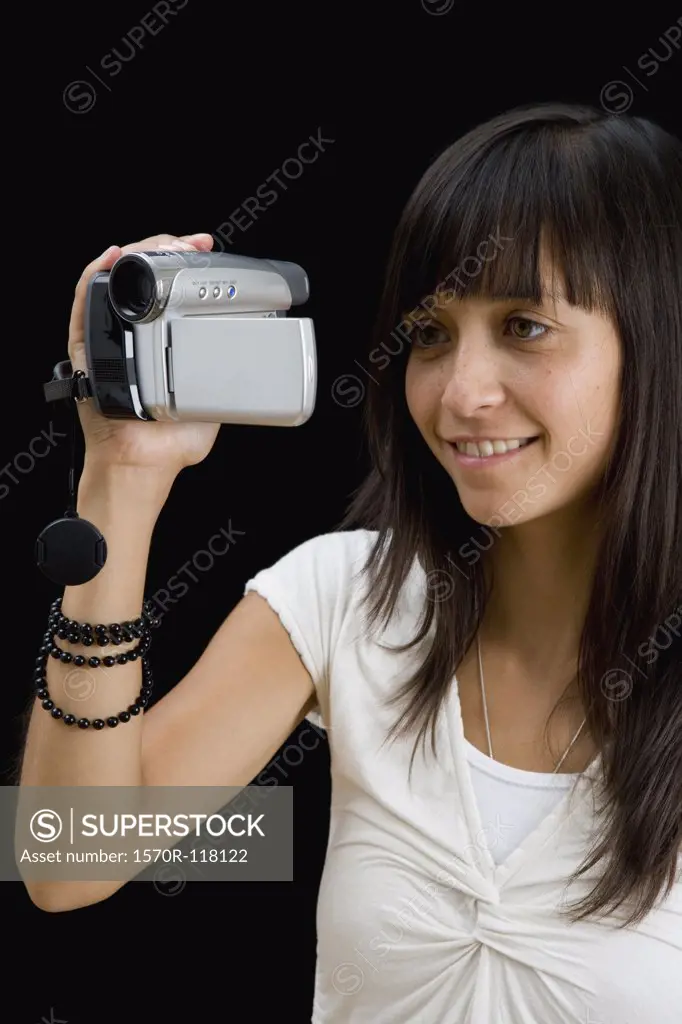A young woman using a video recorder