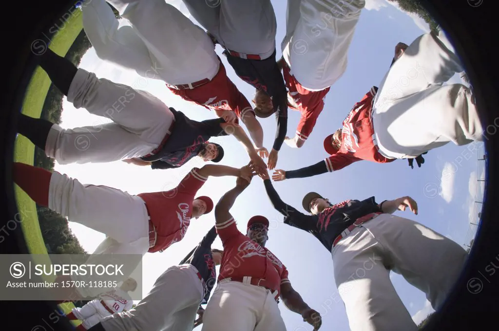 A baseball team with their hands stacked together in a huddle