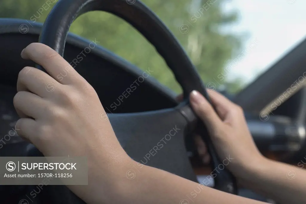 Close-up of hands on a car steering wheel