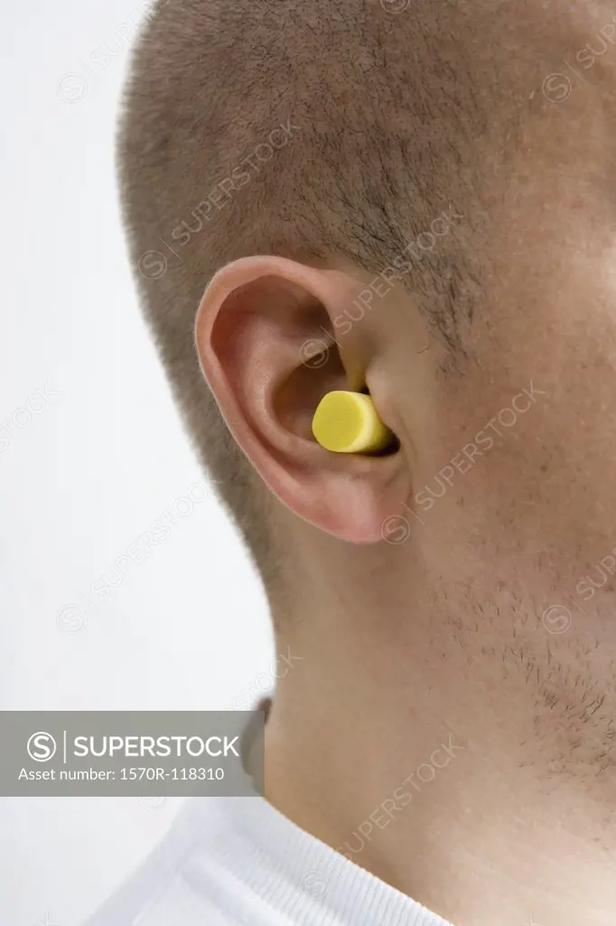 Detail of a man wearing ear plugs