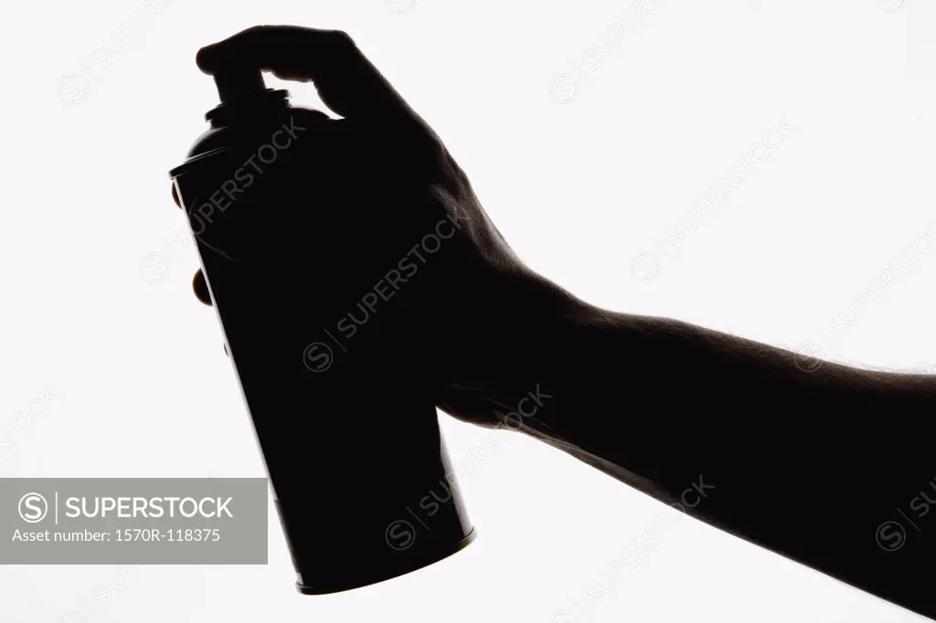 A hand holding an aerosol can