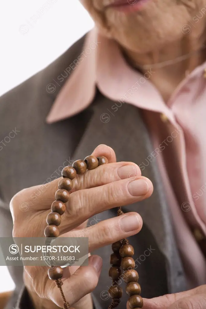 Detail of a woman holding rosary beads