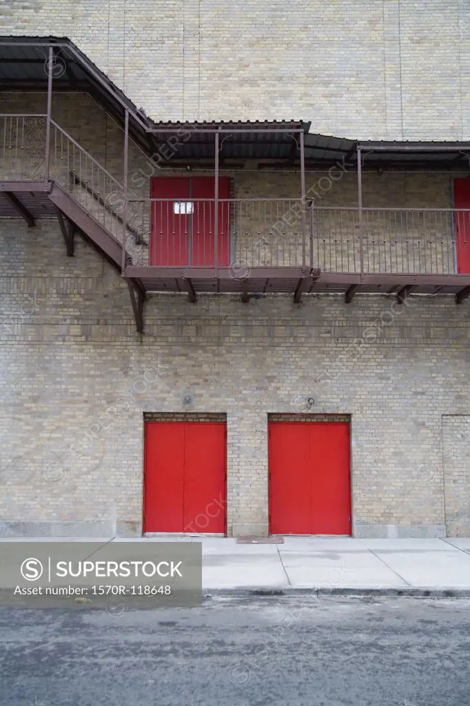 Red doors and a staircase on a building exterior