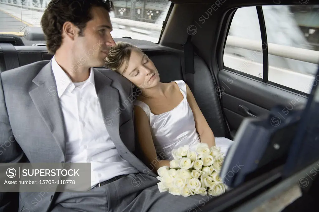 A bride and groom relaxing in a car