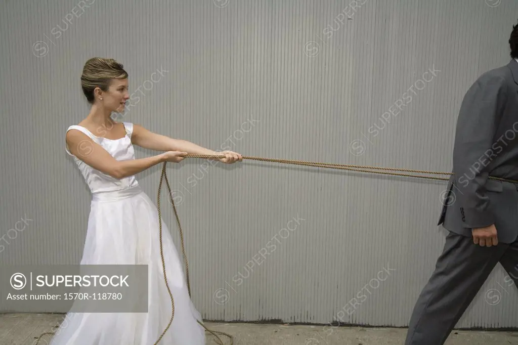 A bride pulling the groom with a rope