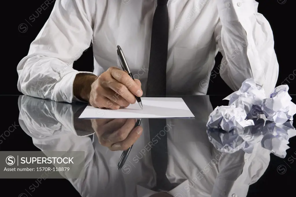 A businessman writing at a desk