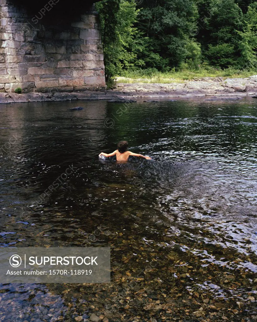 A boy swimming in a river