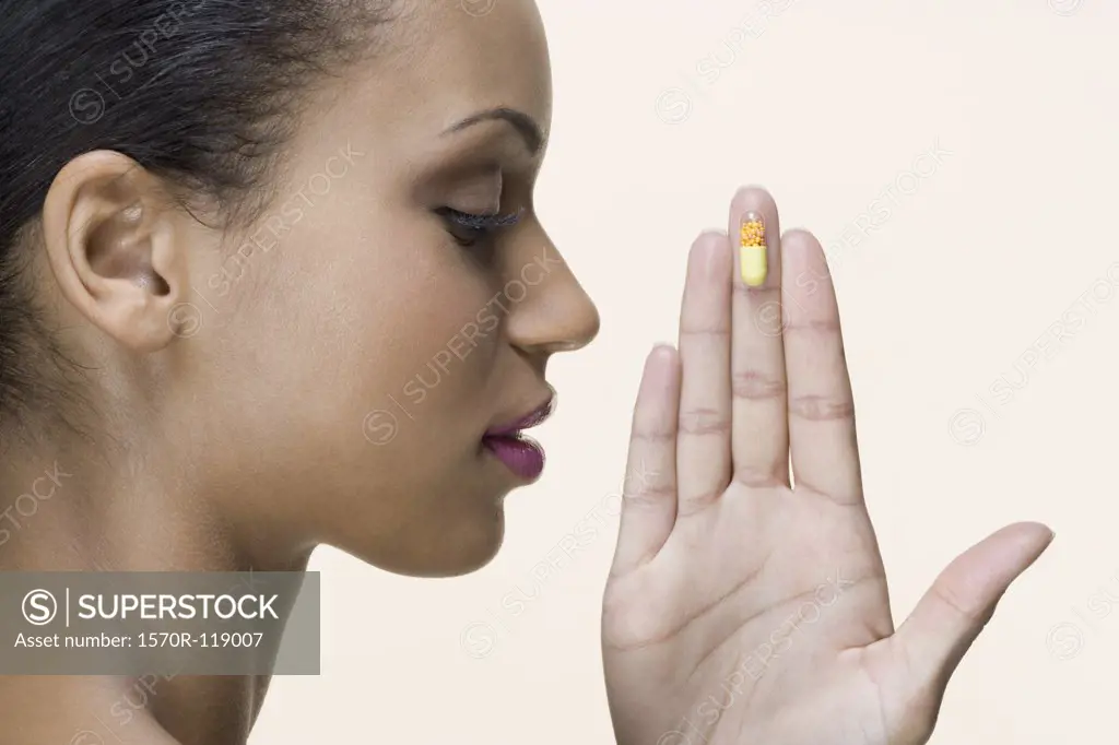 A woman holding a vitamin pill