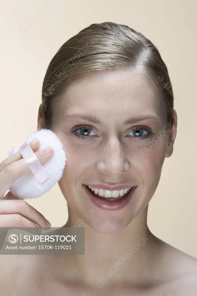A woman holding a powder puff