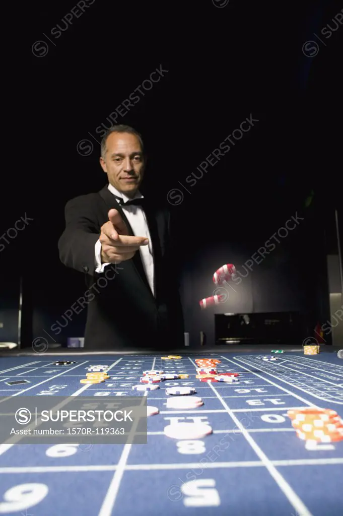 Man throwing gambling chips across a roulette table