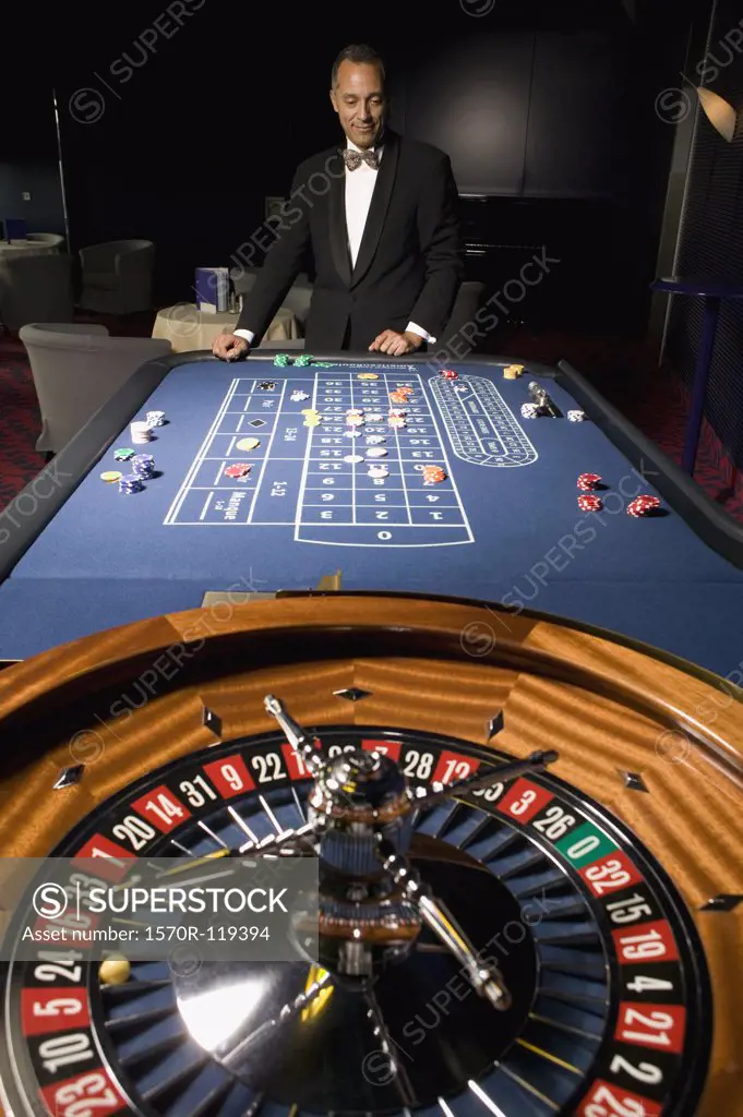 Well dressed man standing at roulette table