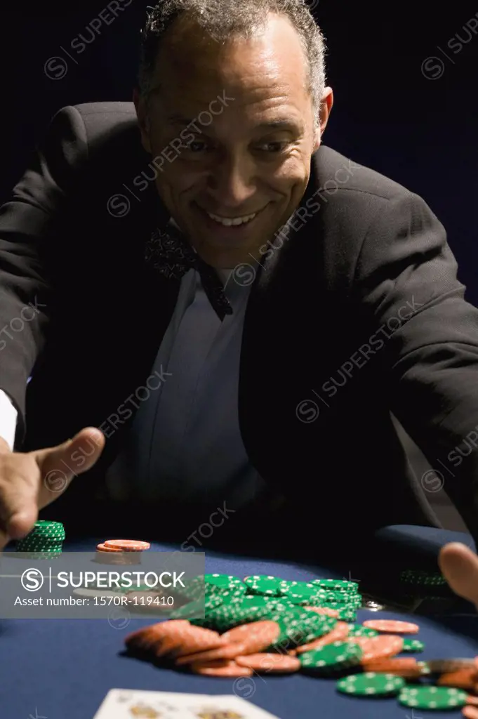 Man gathering winning chips at casino table