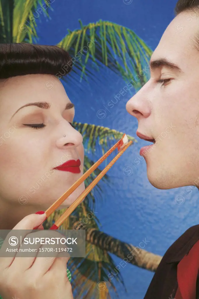 Woman feeding sushi to her boyfriend