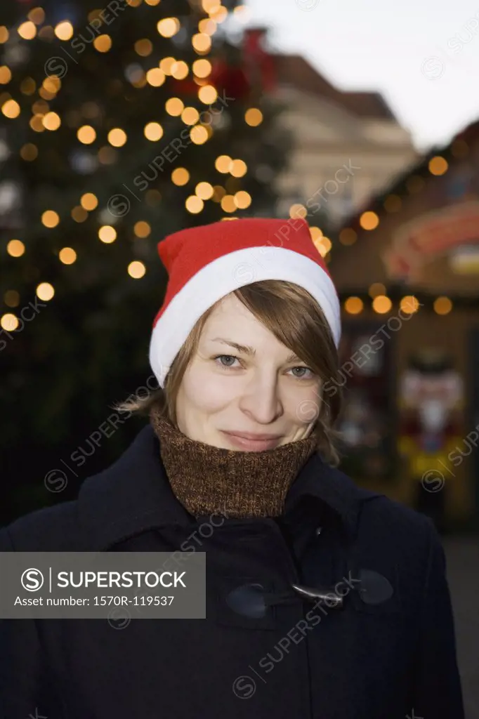 Woman wearing a Santa hat at a Christmas market, Berlin, Germany