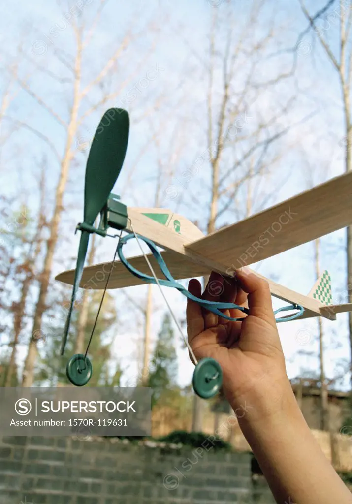 Man holding a rubber band model airplane