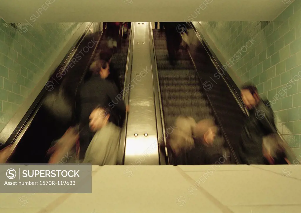 People moving up escalators at a train station