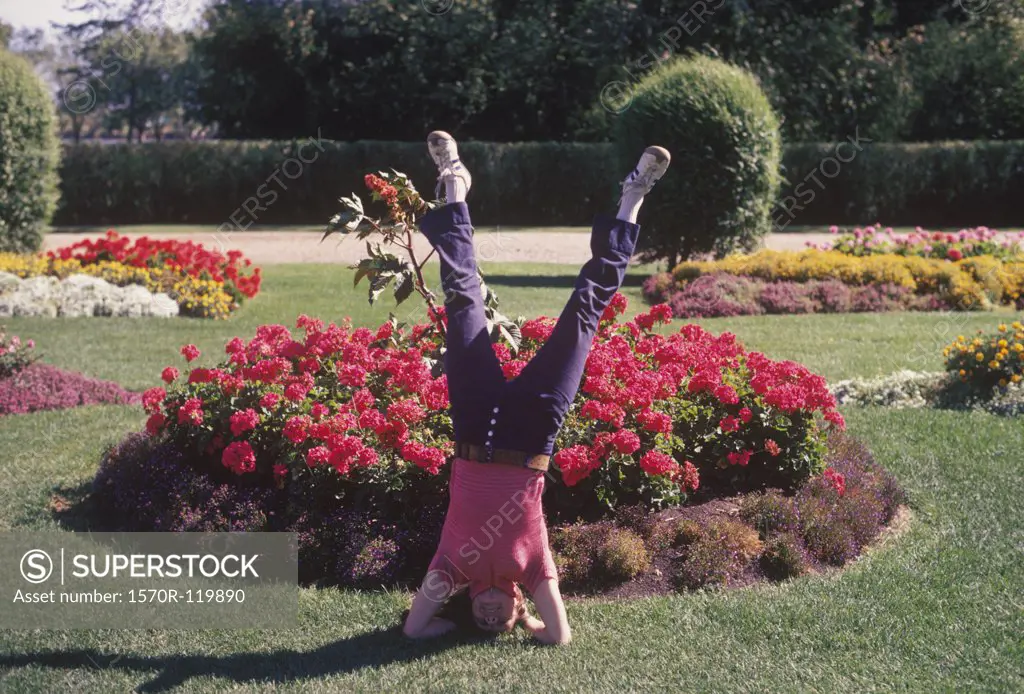 A woman doing a headstand in a park