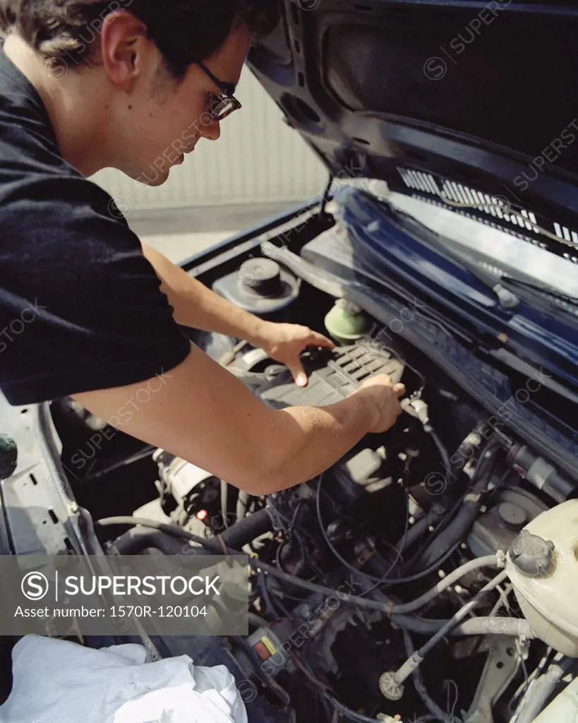Young man checking a car battery