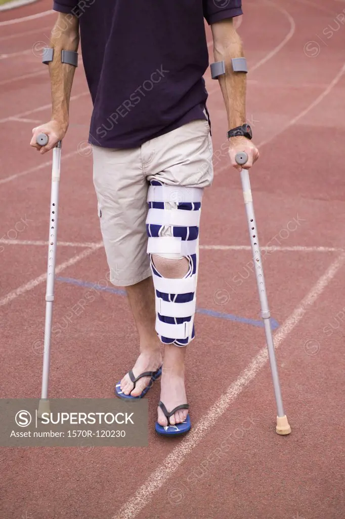 Man with his leg in a brace and using crutches