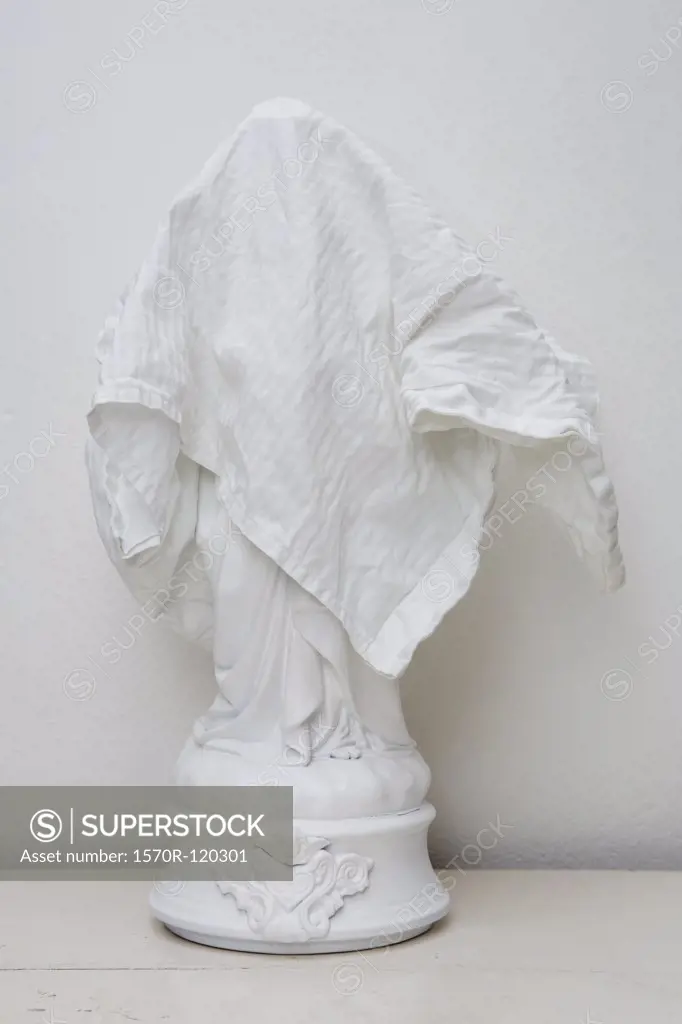 White figurine covered by white cloth