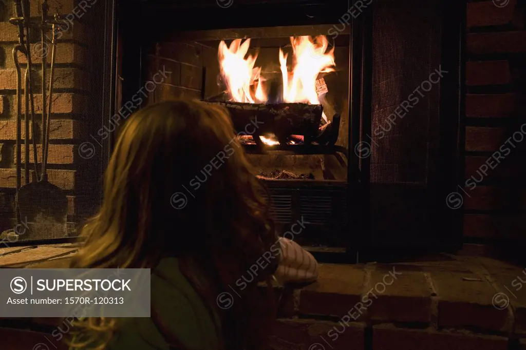 A young girl looking at a fire