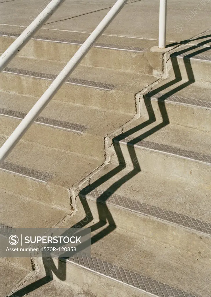 Handrail casting a shadow onto concrete steps